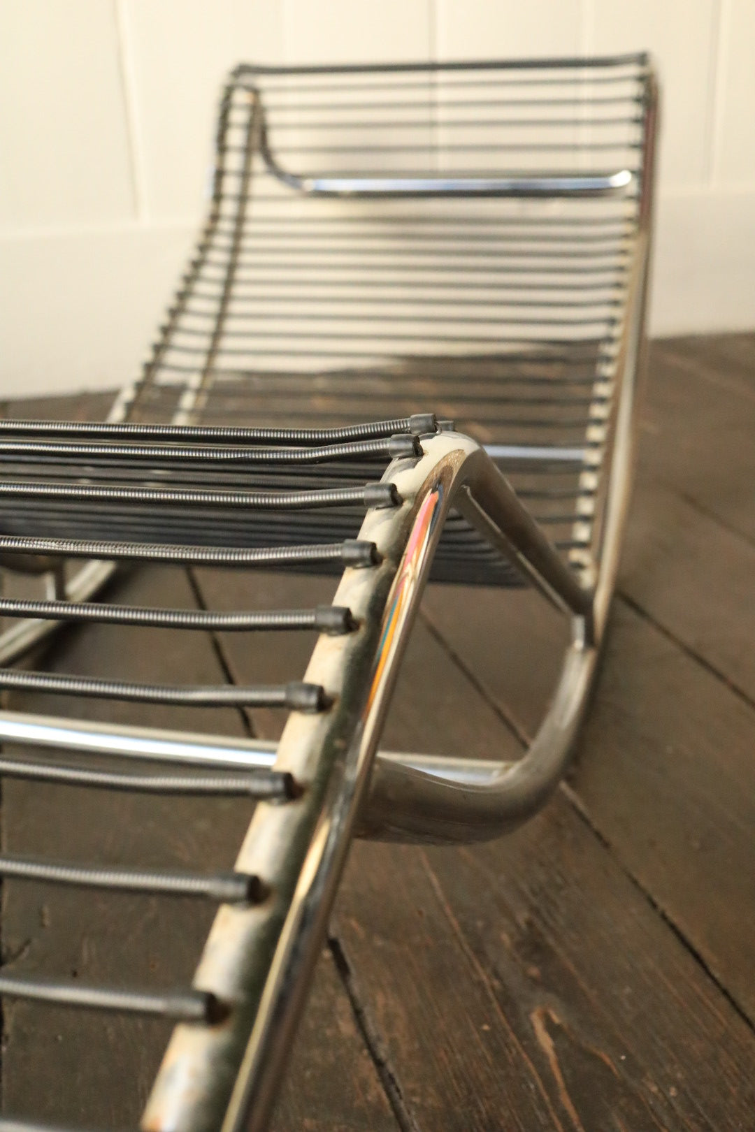 Diagonal view down the length of the exposed chrome frame, capturing spring tension and shiny tubular lines.
