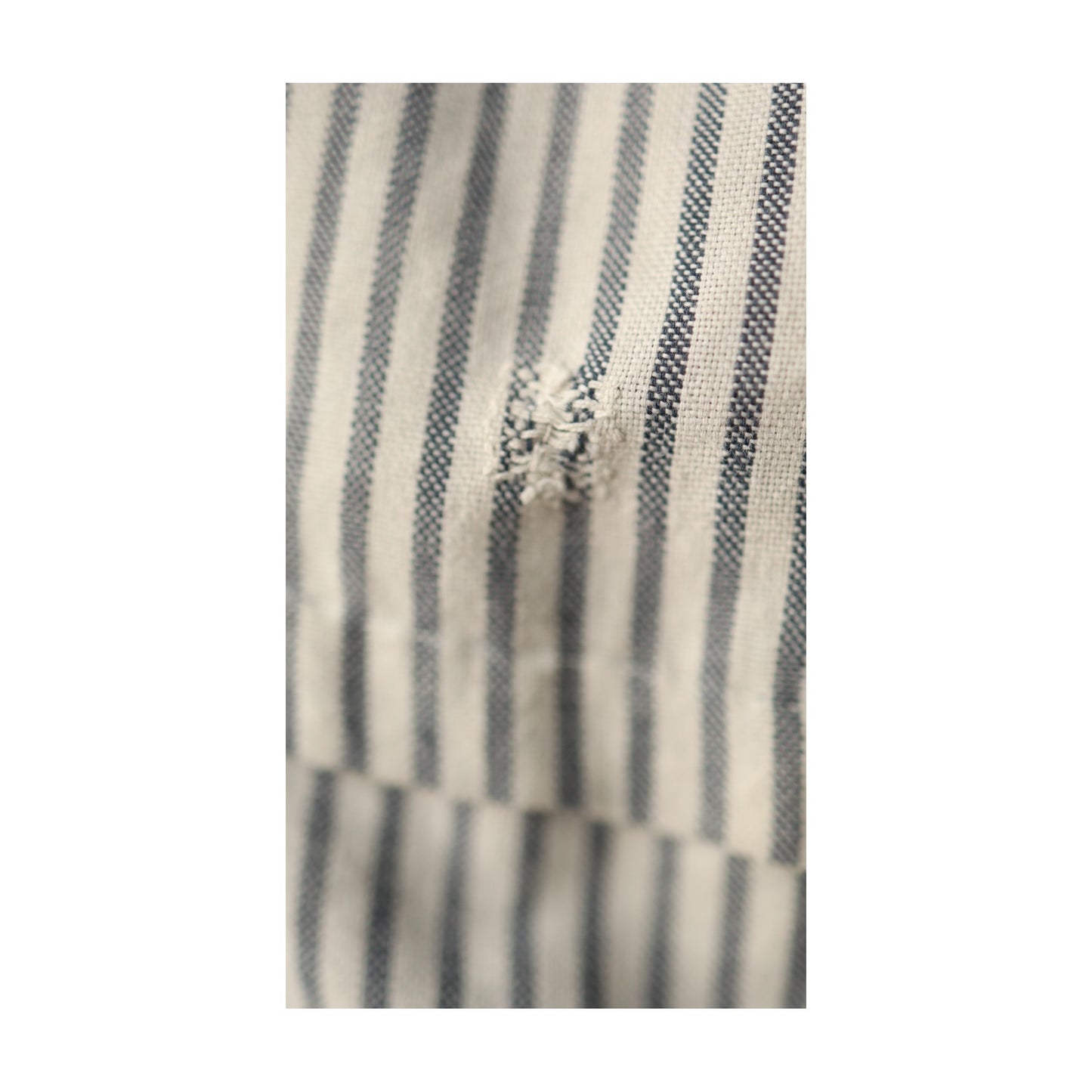 Tightly cropped image of the same mended patch, showing texture and weave of cotton fabric.