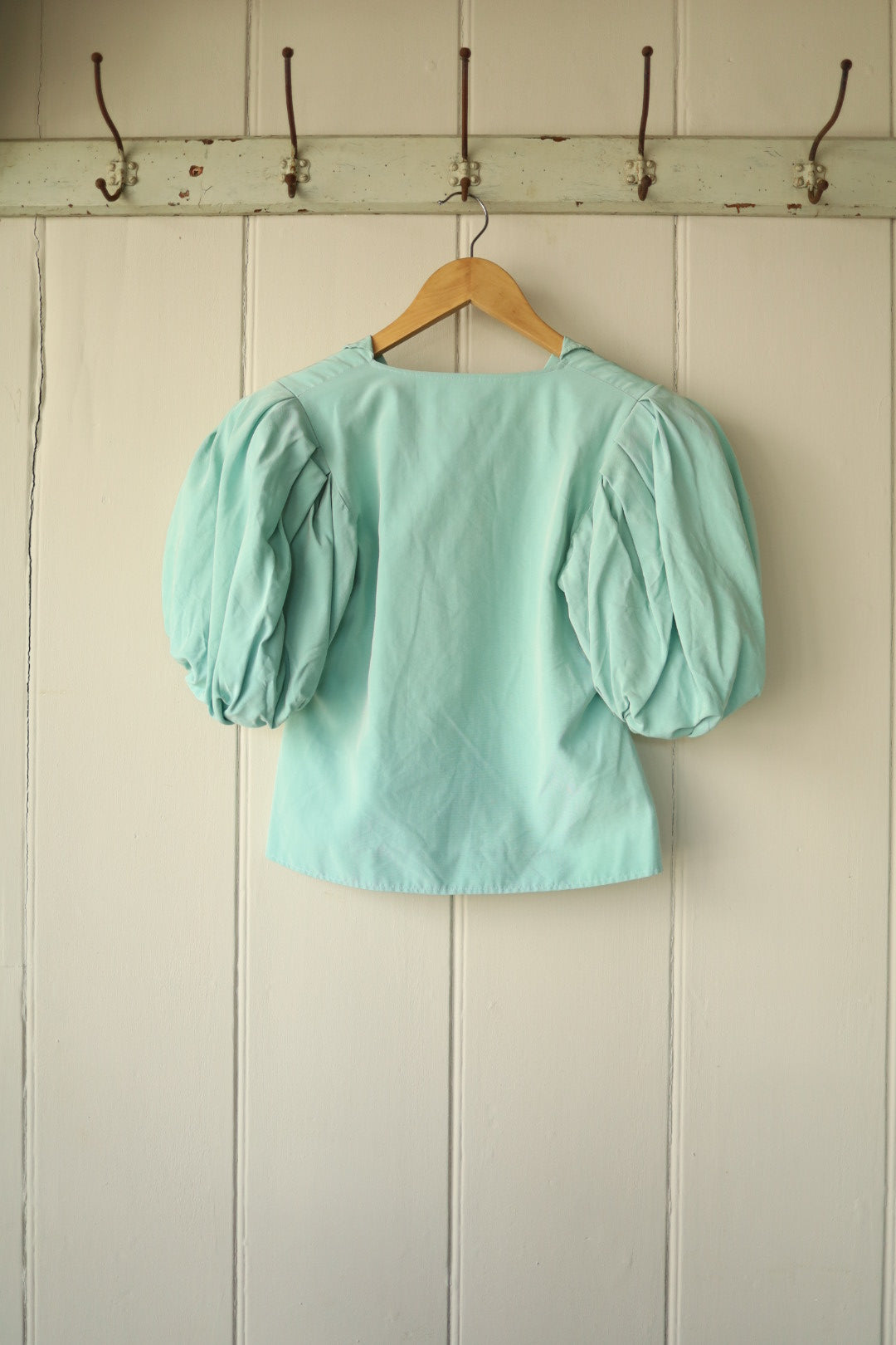 Back view of the Jean Muir mint green short jacket showing structured puff sleeves and cropped cut.