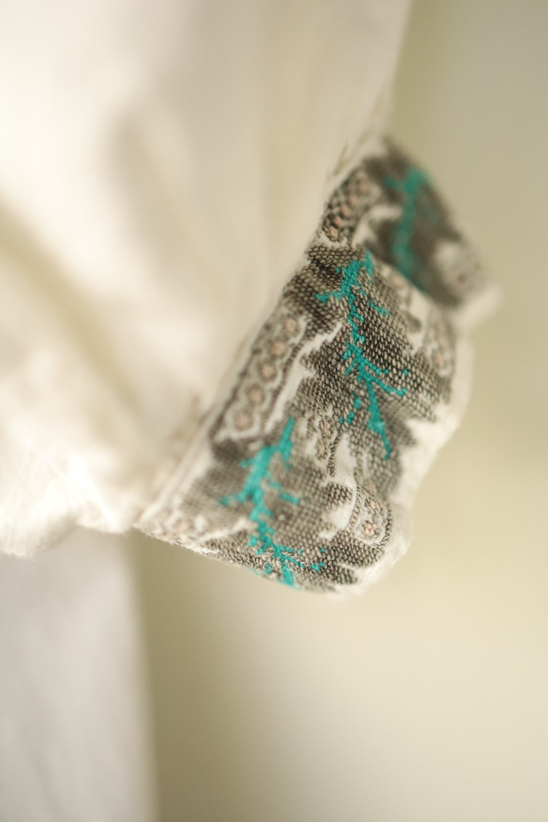Cuff showing folk-style embroidery in earthy tones