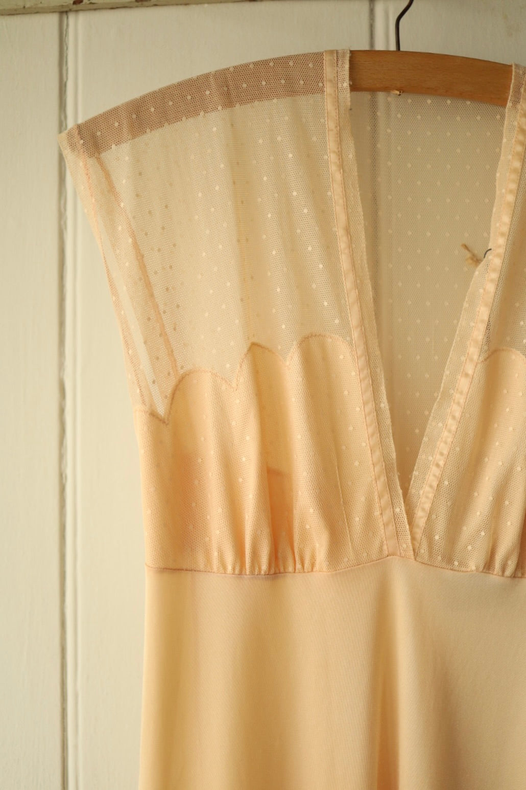 Close-up of the fabric on the vintage nightdress, showing the peach polka dot mesh and smooth satin-style fabric with neatly finished seams.