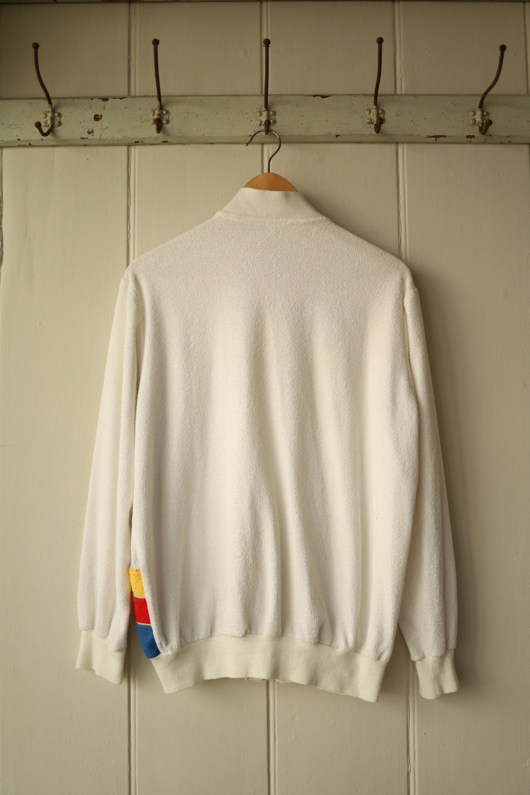 Back view of same cream tracktop showing plain velour back and ribbed hem