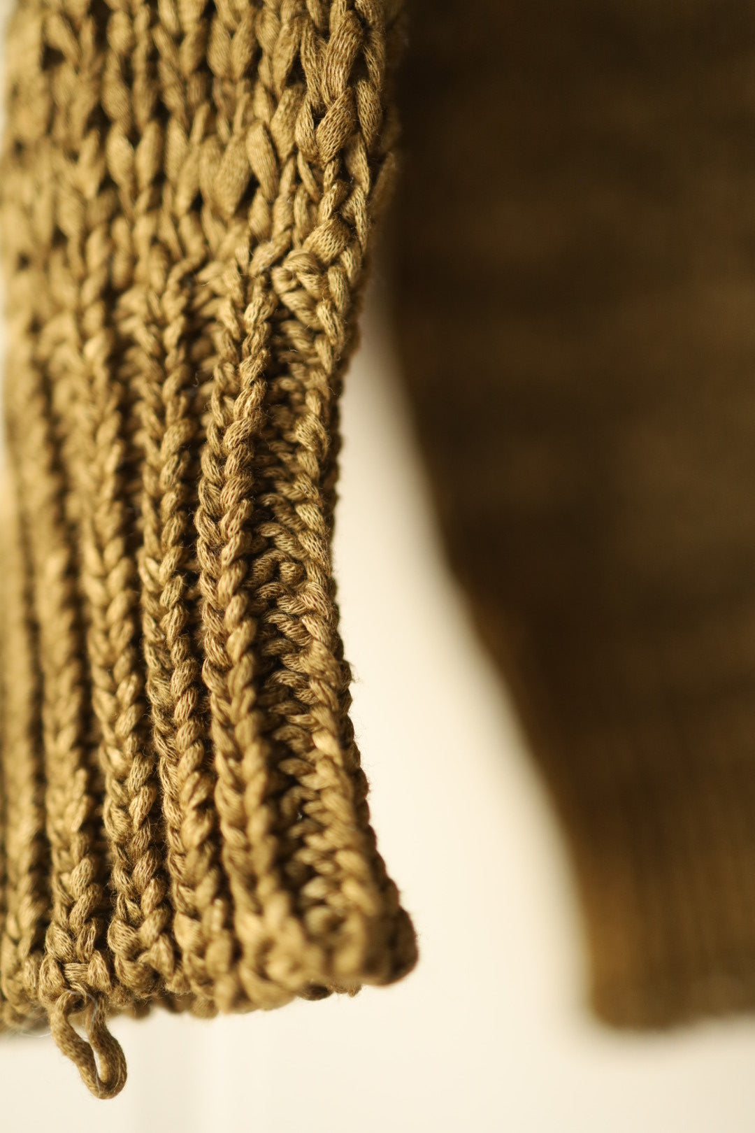 Macro shot of the sleeve cuff showing the dense ribbed knit structure and fine finishing.