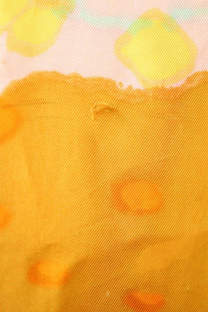 Fabric detail of the back showing a faint thread pull in the yellow-orange section of the abstract pattern.