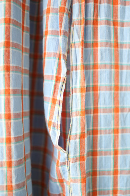Close-up of the open pocket detail and fabric texture, highlighting the soft linen and orange plaid pattern with selvedge edge finish.