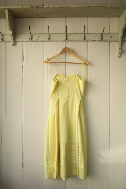 Back view of the dress showing a zip fastening and flattering panel seams, also highlighting the adjustable shoulder ties.