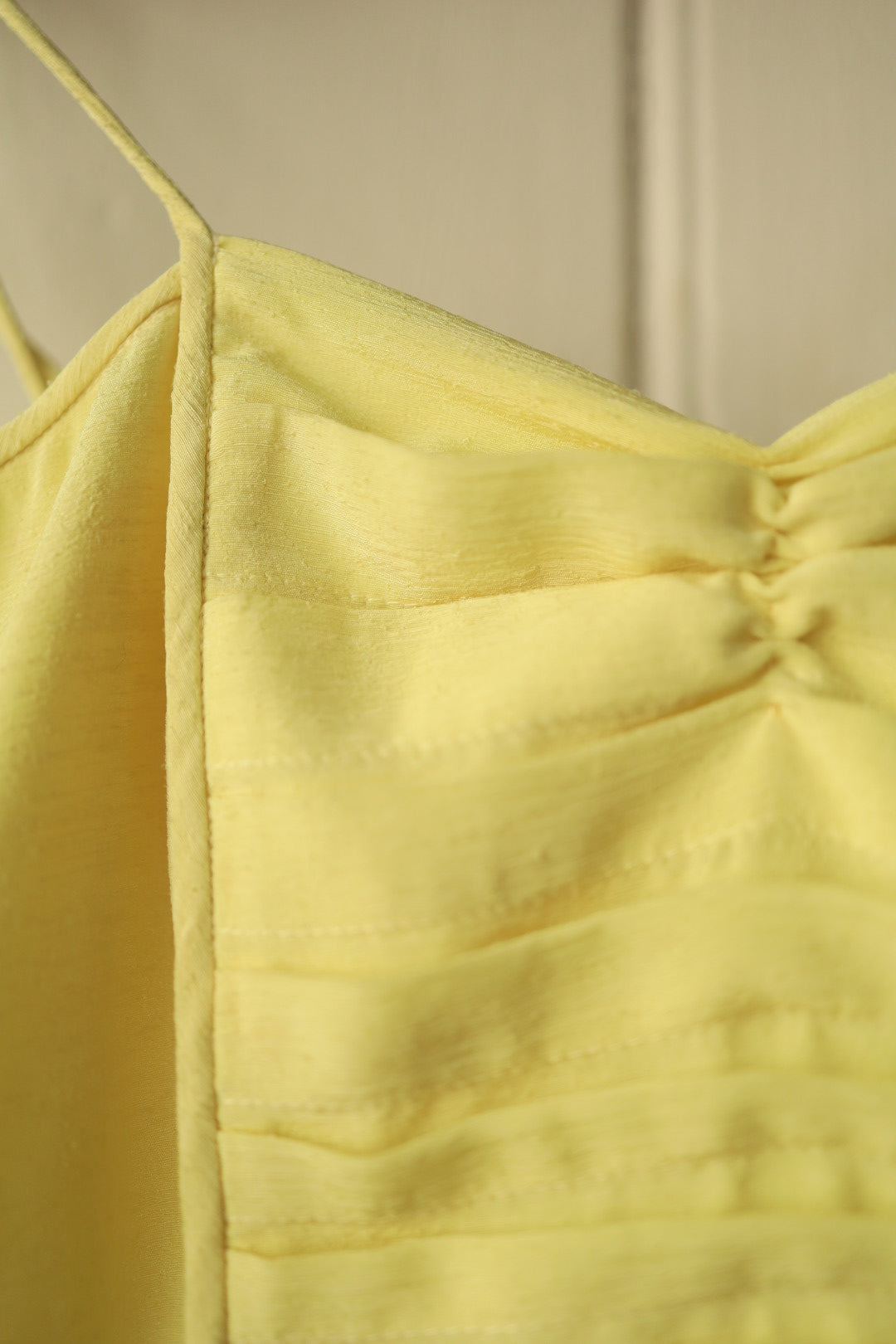 Close-up of the bodice focusing on the pintuck pleats and gathered centre detail of the chest.