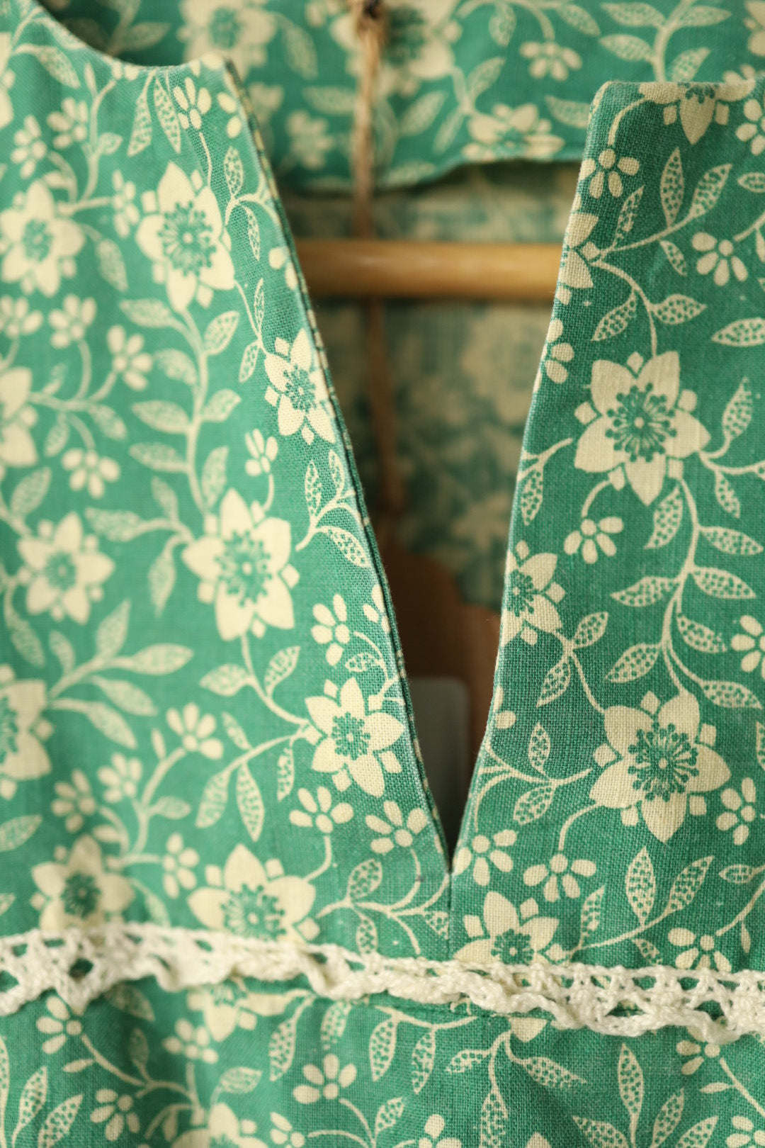 Macro of neckline slit with floral print and lace detail