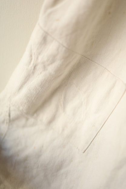 Image showing a patch repair near the pocket seam on the dress’s cream skirt.