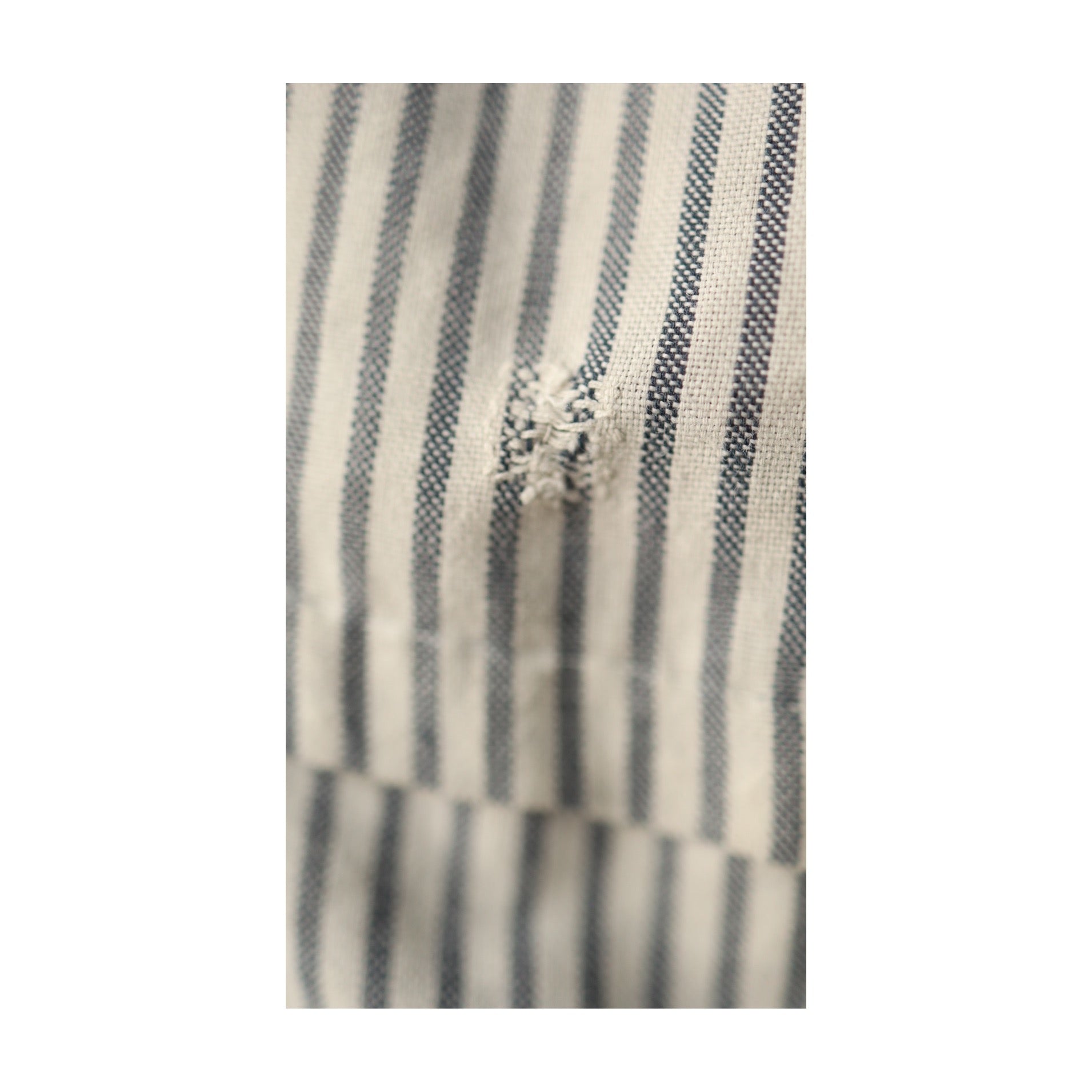Tightly cropped image of the same mended patch, showing texture and weave of cotton fabric.