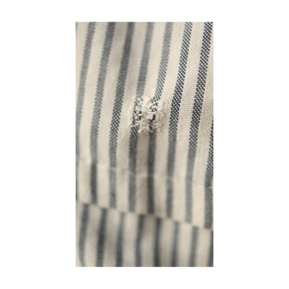 Tightly cropped image of the same mended patch, showing texture and weave of cotton fabric.