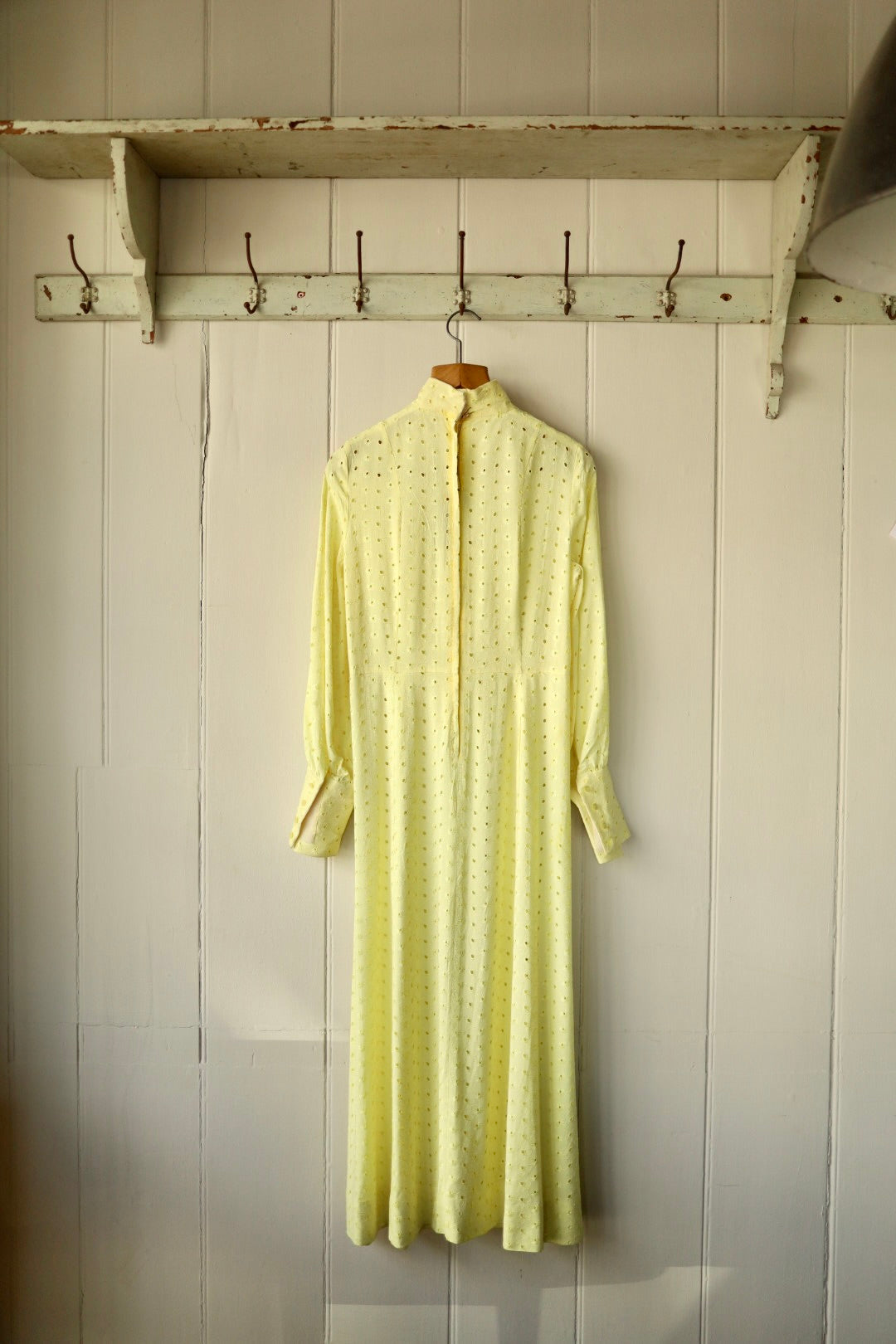 Back view of the yellow broderie anglaise dress showing the zip closure and full-length design.