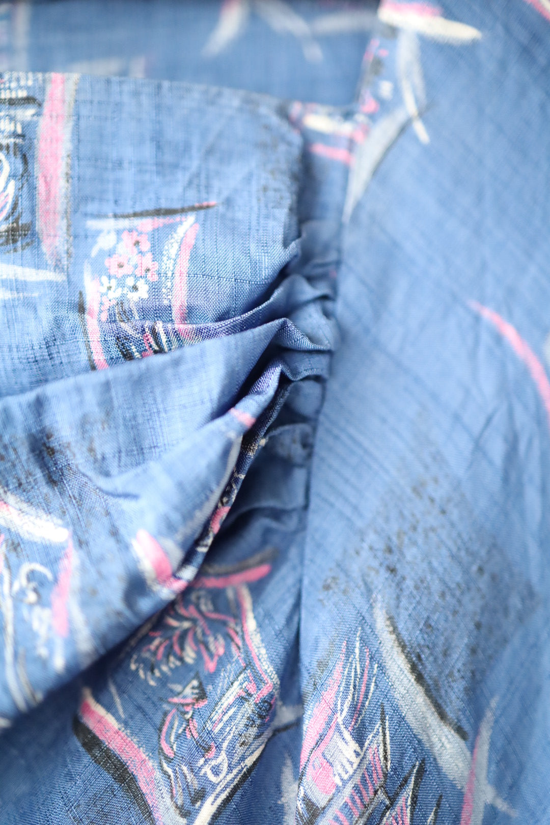 Close-up of gathered front skirt detail showing texture of fabric and printed pattern.