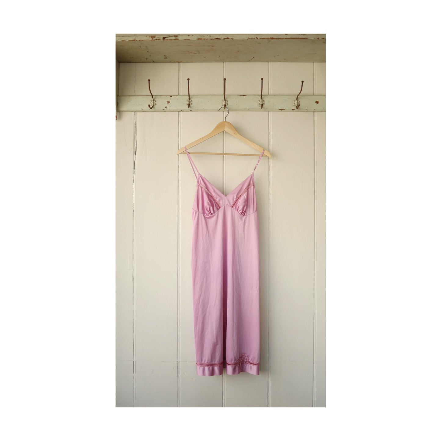 Cropped image of the same petticoat shown in centred format with white borders, photographed hanging neatly against a panelled wall.