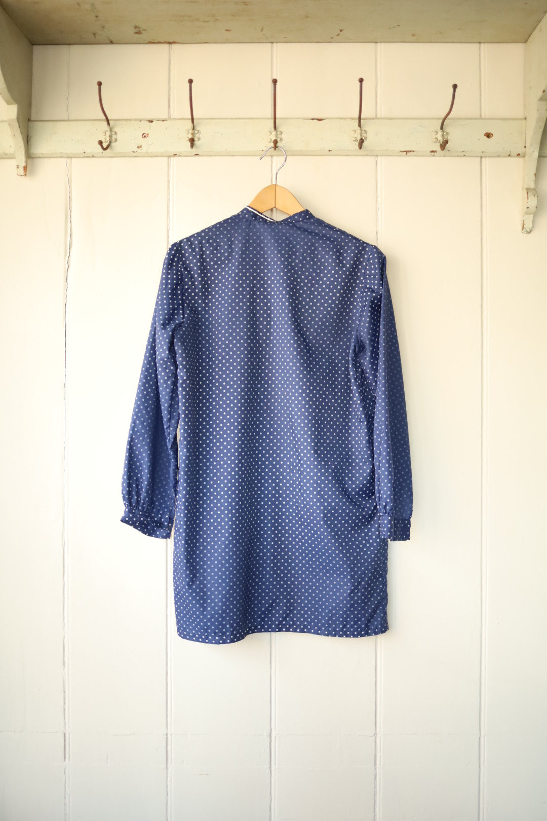 Shows the simple straight cut and pattern of the back of the jacket, with long sleeves and slight gathering at the cuffs.