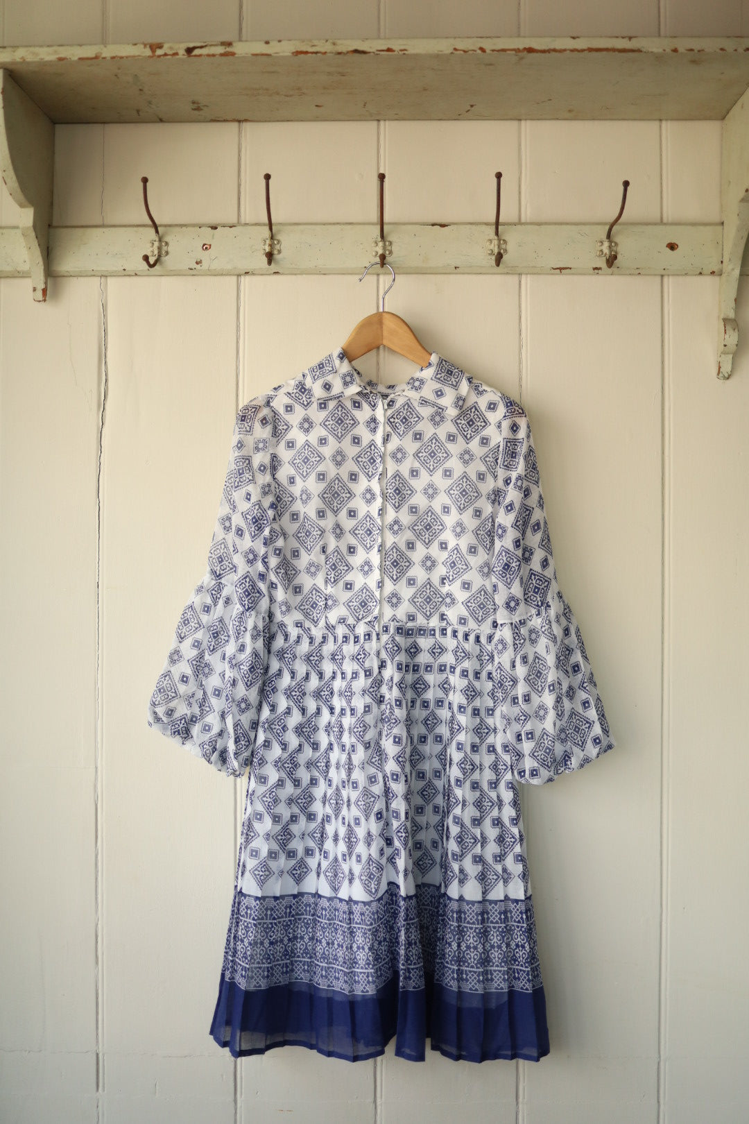 Rear view of the same 70s cheesecloth dress, highlighting the full sleeve detail and zip-back closure, with the patterned fabric gathered at the waist for a voluminous skirt effect.