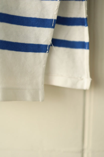 Close-up of the side vent detail on a cream and cobalt blue striped Orcival Breton dress, showing raw edges and textured cotton fabric.
