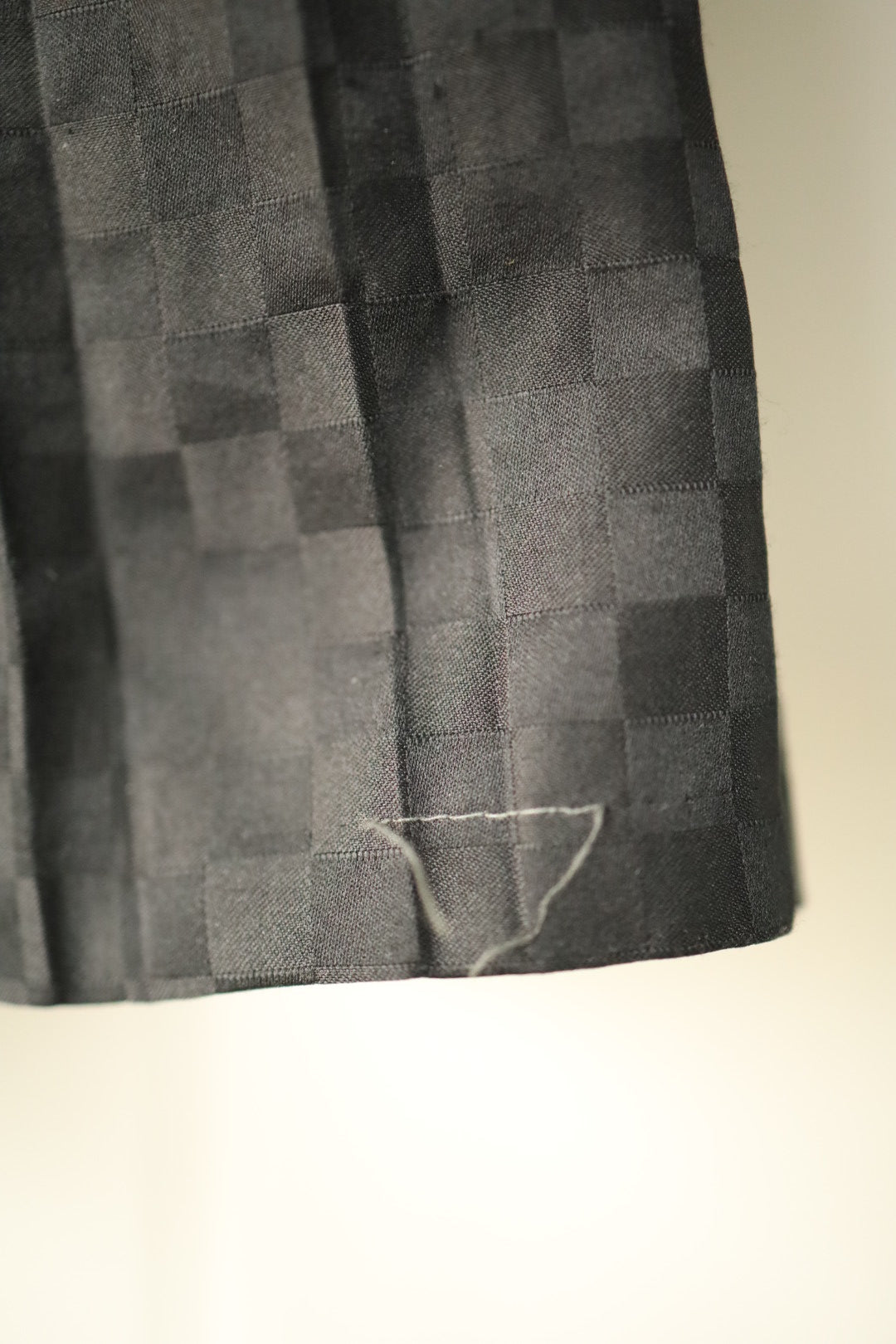 Close-up showing minor loose stitching at hem of skirt
