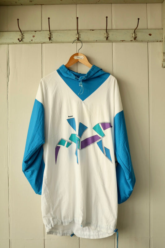 Front view of 1980s graphic smock with bold angular print and turquoise sleeves