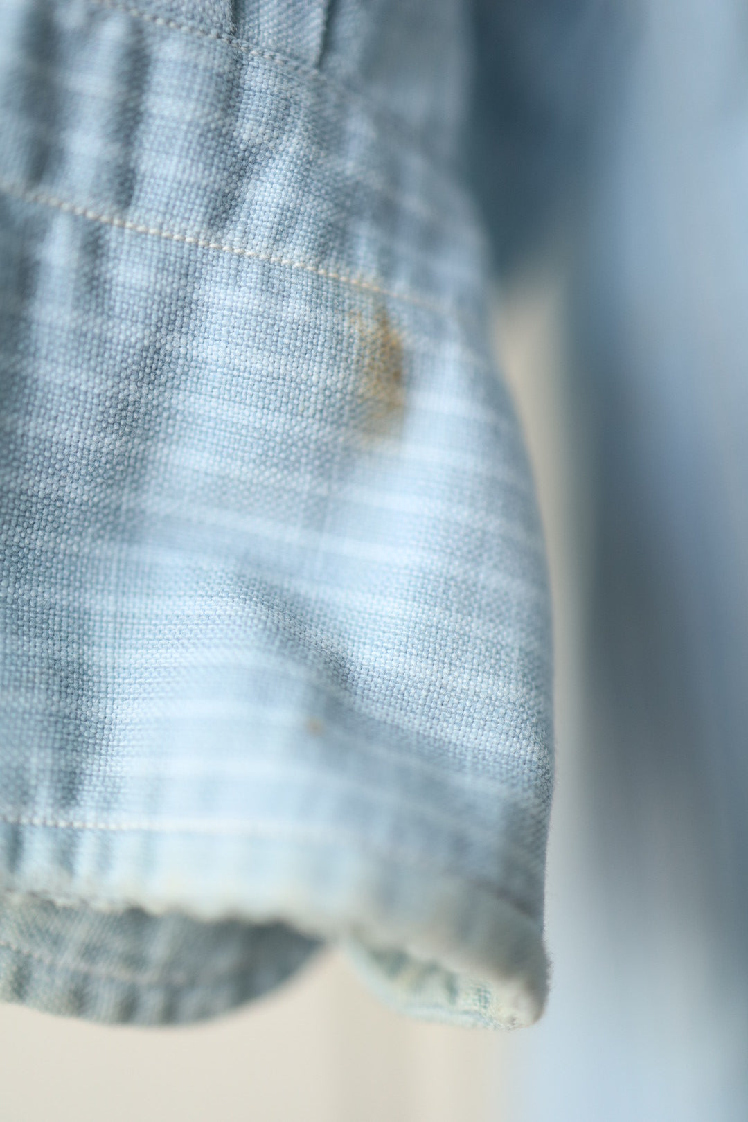 Macro shot of the shirt’s cuff showing minor marks and fraying along the edge.